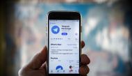 This file photo taken in Moscow shows a person posing while holding a smartphone with the Telegram messenger application on display. (AFP / Alexander NEMENOV)