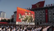 FILE PHOTO: People wave banners and shout slogans as they attend a rally in support of North Korean stance against the US on Kim Il-Sung square in Pyongyang on August 9, 2017 (AFP / Kim Won-Jin) 