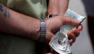 A man holds various English Pound notes as he waits in line to exchange it for Euros notes outside a money exchange office in the British overseas territory of Gibraltar June 24 2016 AFP
