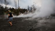 Resident Stacy Welch inspects fissures located near her home, which remains standing, in the Leilani Estates neighborhood in the aftermath of eruptions from the Kilauea volcano on Hawaii's Big Island on May 7, 2018 in Pahoa, Hawaii. Mario Tama/Getty Image