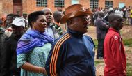 Burundi's President Pierre Nkurunziza (2R) waits with his wife Denise (3R) as they queue to cast their votes for the referendum on a controversial constitutional reform in Buye, northern Burundi, on May 17, 2018.  AFP / STR
