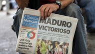 A man holds a newspaper referring to the victory of re-elected President Nicolas Maduro in the Venezuelan presidential election in Caracas, on May 21, 2018. AFP / Luis ROBAYO
