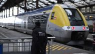 (FILES) In this file photo taken on April 3, 2018, a security staff stands near a train inside Gare de Lyon railway station in Paris at the start of three months of rolling rail strikes. AFP / Christophe Simon
