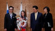 Endo Takashi, head of the Association for the preservation of the purity of the Akito breed, Russian figure skating gold medallist Alina Zagitova, Japanese Prime Minister Shinzo Abe and his wife Akie Abe poses with an Akita Inu puppy presented to Zagitova