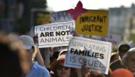 (FILES) In this file photo taken on June 14, 2018, critics of US government policy which separates children their parents when they cross the border illegally from Mexico protest during a 'Families Belong Together March', in downtown Los Angeles, Californ