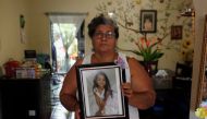 Ana Henriquez poses for a picture while holding a photograph of her granddaughter Alison Valencia, who was detained along with her mother and then separated when they arrived in the US in Armenia, El Salvador June 20, 2018. Reuters/Jose Cabezas