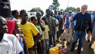 FILE PHOTO: EU Commissioner for Humanitarian and Crisis Management Christos Stylianides speaks with newly arrived refugees from South Sudan to Uganda.  (AFP / Isaac Kasamani)