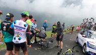 Team Sky rider Chris Froome of Britain who was mistaken for a fan is pulled off his bike by a police officer as he makes his way to the Team Sky bus from the summit finish on Col du Portet, Haute Pyrenees, France, July 25, 2018 in this picture obtained fr