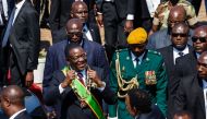 Zimbabwe President Emmerson Mnangagwa (C) gestures during the Heroes Day commemorations held at the National Heroes Acre in Harare August 13, 2018.  AFP / Jekesai Njikizana  