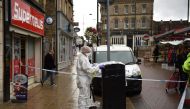 A police forensics officer looks for evidence inside a cordon in Peel Square, following a stabbing incident in the centre of Barnsley, northern England on September 8, 2018.   AFP / Oli SCARFF