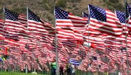 A family visitS the 'Waves of Flags' display at Pepperdine University in Malibu, California on September 10, 2018, where the annual display of 2,997 flags commemorates victims of the September 11, 2001 terrorist attacks. / AFP / Frederic J. BROWN 