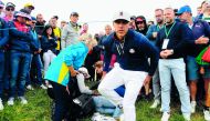 US golfer Brooks Koepka (R) reacts next to an injured spectator who fell during the fourball match on the first day of the 42nd Ryder Cup at Le Golf National Course at Saint-Quentin-en-Yvelines, south-west of Paris on September 28, 2018. AFP / Franck Fife