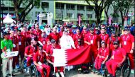 The head of the Qatari mission, Abdulqader Al Mutawa, and team members with Qatari flag at the Olympic village for the Asian Para Games in Jakarta. 