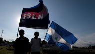 Supporters of Nicaraguan President Daniel Ortega hold flags of Nicaragua and the Sandinista party during a march called 