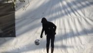 A Central American migrant taking part in a caravan towards the US, plays with a ball at a stadium-turned-shelter during a stop in the journey, in Mexico City on November 7, 2018.  AFP / Alfredo Estrella 

 