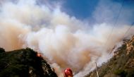 Firefighters battle the Woolsey Fire as it continues to burn in Malibu, California, U.S., November 11, 2018. Reuters/Eric Thayer