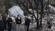 President Donald Trump (C) surveys the damage from the Woolsey fire in Malibu on November 17, 2018. / AFP / POOL / Genaro Molina