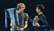 Germany's Alexander Zverev (L) chats to Serbia's Novak Djokovic as they pose with their trophies after the men's singles final match on day eight of the ATP World Tour Finals tennis tournament at the O2 Arena in London on November 18, 2018. AFP / Glyn KIR