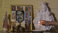 Maria Eugenia Castano, resident of Pablo Escobar neighborhood, lights a candle at the portrait of Colombian drug lord Pablo Escobar in her house on November 28, 2018, in Medellin, Colombia. / AFP / Raul ARBOLEDA 