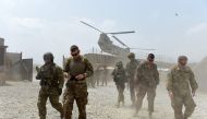 US army soldiers walk as a NATO helicopter flies overhead at coalition force Forward Operating Base (FOB) Connelly in the Khogyani district in the eastern province of Nangarhar, Afghanistan on August 12, 2015,  AFP / Wakil Kohsar
 

