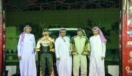 Qatari driver Mohamed Al Meer (fourth left) and his Russian co-driver Alexey Kuzmich celebrate with the  President of Qatar Motor and Motorcycle Federation (QMMF),  Abdulrahman Al Mannai (centre) and General Secretary Abdul Razzaq Al Kuwari (right) after 