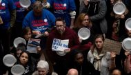 A federal worker stands with a placard reading 