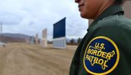 A US Border Patrol officer stands near prototypes of border wall proposed by US President Donald Trump on November 1, 2017 in San Diego. AFP/Frederic J Brown