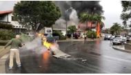 A man puts out fire on a piece of debris from a plane that crashed into a house in a residential neighborhood in Yorba Linda, California, U.S., February 3, 2019, in this still image from video obtained from social media. Joshua Nelson/via REUTERS