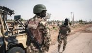 FILE PHOTO: Soldiers of the 7th Division of the Nigerian Army stand by the road in Damboa Borno State, northeast Nigeria on March 25, 2016. AFP/Stefan Heunis 