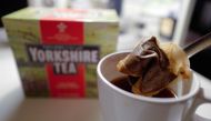 A man poses making a cup of tea with a Yorkshire Tea teabag with a box of tea in the background arranged as an illustration in London on December 19, 2018. AFP/Tolga Akmen