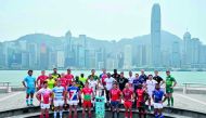 Captains of teams competing in the annual Hong Kong Rugby Sevens pose with the winner's trophy (C) in front of a view of the skyline in Hong Kong on April 3, 2019, during a promotional event ahead of the tournament. AFP / Anthony Wallace 