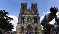 The pack rides with the Cathedral of reims in background during the third stage of the 106th edition of the Tour de France cycling race between Binche and Epernay, in Reims, on July 8, 2019. AFP / Jeff Pachoud
 
 