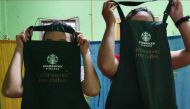 Workers show Starbucks aprons at a dormitory near a factory in Thailand's Mae Sot district in August 2019. Thomson Reuters Foundation/Nanchanok Wongsamuth