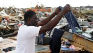 A man hangs his clothes after washing them at the Mudd neighborhood, devastated after Hurricane Dorian hit the Abaco Islands in Marsh Harbour, Bahamas, September 6, 2019. Reuters/Marco Bello
 