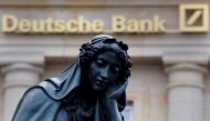 A statue is seen next to the logo of Deutsche Bank in Frankfurt,  Germany, January 26, 2016. Reuters /  Kai Pfaffenbach 