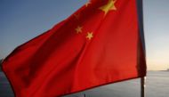 N Korean fishermen are seen as a Chinese flag flutters from the Broken Bridge as the sun sets over Yalu River between N Korean town of Sinuiju Dandong in Liaoning Province, China, Nov 19, 2017. Reuters / Damir Sagolj