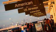 This December 9, 2013 photo shows American Airlines and US Airways signs stand next to each others at Denver International Airport, Colorado. AFP / Emmanuel Dunand