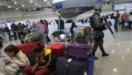 A Brazilian soldier patrols past travelers in the Galeao international airport in Rio de Janeiro, July 24, 2016. Reuters/Ricardo Moraes
 