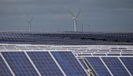 A solar power plant is seen past wind turbines in Canino central Italy, April 27, 2016. Reuters / Max Rossi