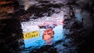 This picture shows an electoral poster of the candidate of the anti-immigrant right-wing Swiss People's Party (SVP) Jean-François Thuillard reflected in a puddle on October 18, 2019 in Chavannes de Bogis, Western Switzerland. AFP / Fabrice COFFRINI