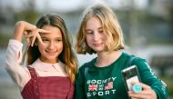 Russian child blogger Liza Anokhina (L), 12, participates in a shoot for her blog in a Moscow park on September 13, 2019. AFP / Alexander Nemenov 
