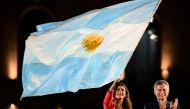 Argentina's President and presidential candidate of the Juntos por el Cambio party, Mauricio Macri (R), applauds as First Lady Juliana Awada was a national flag during the closing rally of his campaign in Cordoba, Argentina, on October 24, 2019. AFP / Ron