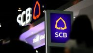 People walk pass the logos of Siam Commercial Bank at an exhibition hall in Bangkok, Thailand, May 12, 2016. Reuters/Athit Perawongmetha