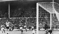 England's forward Martin Peters (16), followed by his teammate Roger Hunt, celebrates after scoring during the World Cup final. London. July 30, 1966. / AFP / STRINGER
