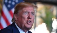 In this file photo taken on December 24, 2019 US President Donald Trump answers questions from reporters after making a video call to the troops stationed worldwide at the Mar-a-Lago estate in Palm Beach Florida