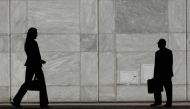 People are silhouetted at Canary Wharf business district in London May 1, 2007. Reuters/Luke MacGregor