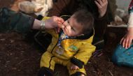 An internally displaced man pinches the cheek of a child wearing socks with a hole at a makeshift camp in Azaz, Syria February 19, 2020. Reuters/Khalil Ashawi
 