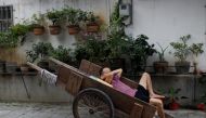 FILE PHOTO: A man sleeps in a cart near a market in the traditional neighbourhood of Yuexiu in Guanghzou, China, September 8, 2019. Reuters / Jorge Silva