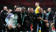 Manchester City's Bernardo Silva, Benjamin Mendy, Riyad Mahrez and Raheem Sterling pose with the trophy as they celebrate after winning the Carabao Cup. Action Images via Reuters/Matthew Childs 