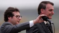 Chief of the Secretariat of Social Communication Fabio Wajngarten mutes the microphone for Brazil's President Jair Bolsonaro, during a Flag Day ceremony at the Alvorada Palace, in Brasilia, Brazil November 19, 2019. Reuters/Ueslei Marcelino
